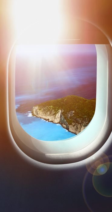 Approaching solitaire paradise island holiday sunshine destination, jet plane window sky view